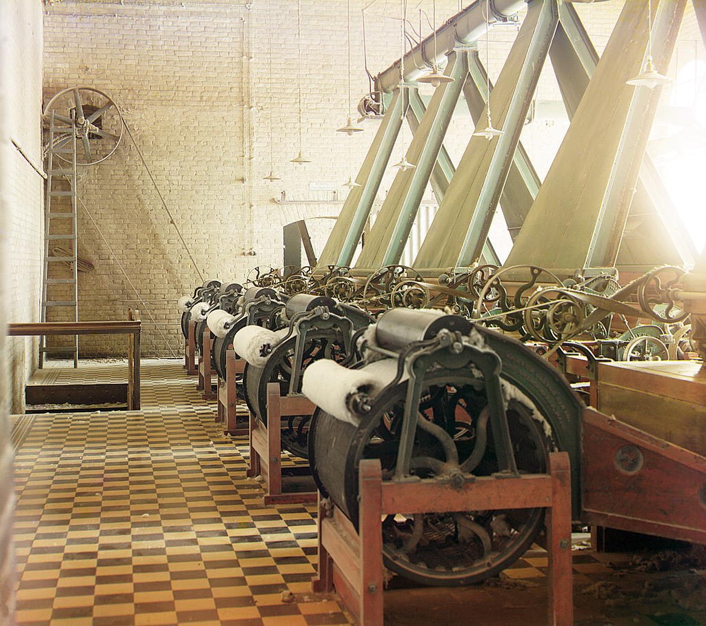 Picture of: Cotton textile mill interior with machines producing cotton thread